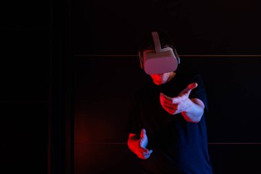 Sanal gerçeklik gözlüğü kullanan oyuncu evde havalı ışıklarla eğleniyor..