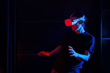 Sanal gerçeklik gözlüğü kullanan oyuncu evde havalı ışıklarla eğleniyor..