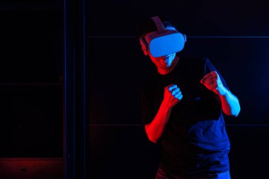 Sanal gerçeklik gözlüğü kullanan oyuncu evde havalı ışıklarla eğleniyor..