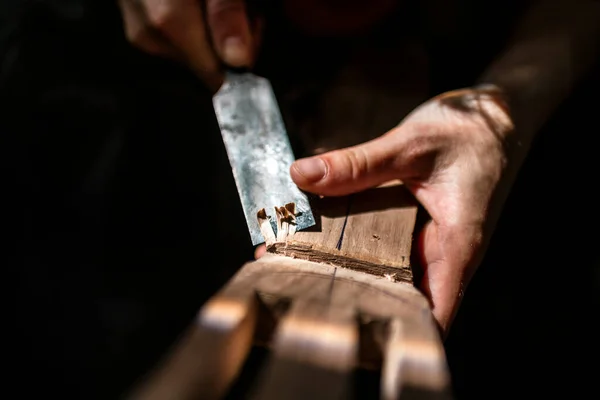 Tanınmayan luthier bir gitar yaratıyor ve geleneksel bir atölyede araçlar kullanıyor.