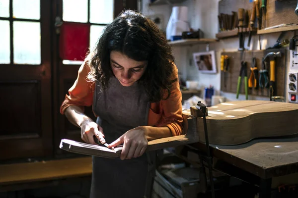 Woman luthier making guitars in her musical instrument workshop — Stock Photo, Image