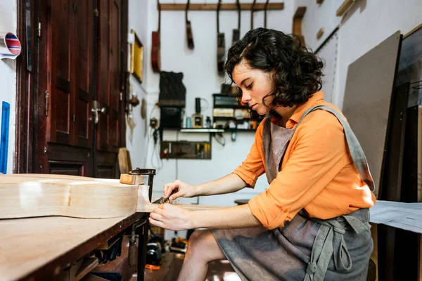 Γυναίκα luthier κάνοντας κιθάρες στο εργαστήρι μουσικών οργάνων της — Φωτογραφία Αρχείου