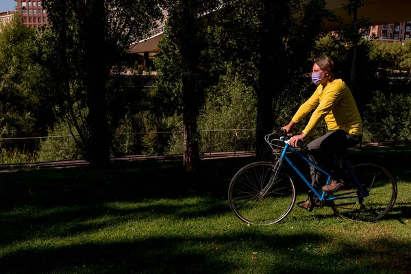 Mann mit Gesichtsmaske im Park mit Fahrrad — Stockfoto