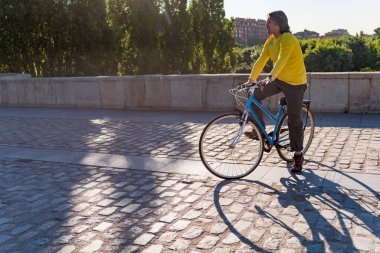 Şehirde bisiklet süren beyaz bir adam.