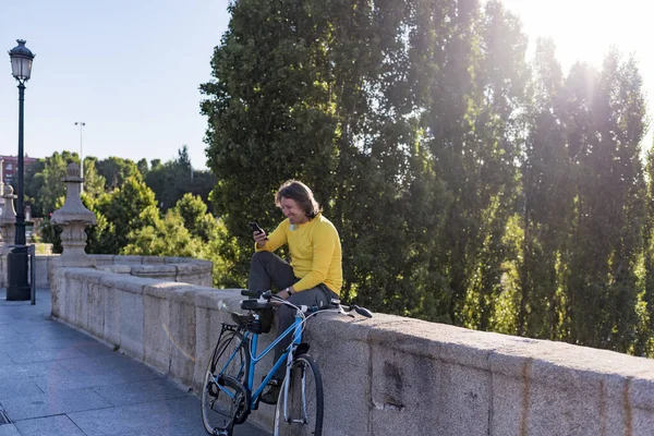 Kaukasier mit Handy und Fahrrad in der Stadt — Stockfoto