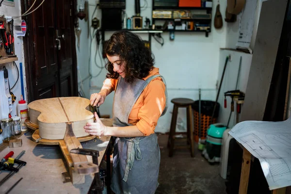 Woman luthier making guitars in her musical instrument workshop — Stock Photo, Image