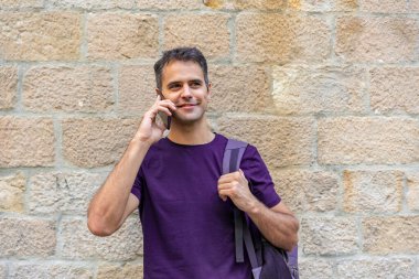 Dışarıda cep telefonu olan genç bir latin.