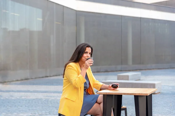 Белая деловая женщина отдыхает и пьет кофе на улице — стоковое фото