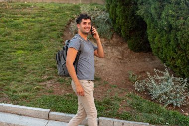 Şehirdeki genç latin adam cep telefonuyla konuşuyor..