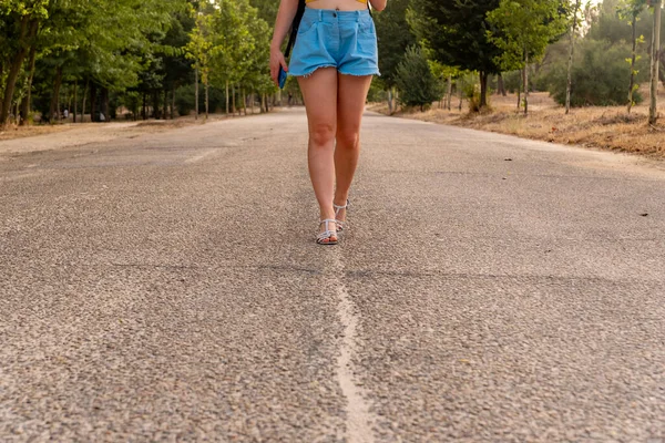 Неузнаваемая девушка, идущая посреди улицы. — стоковое фото