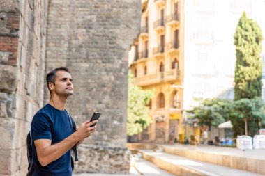 Dışarıda cep telefonu olan genç Latin bir turist.