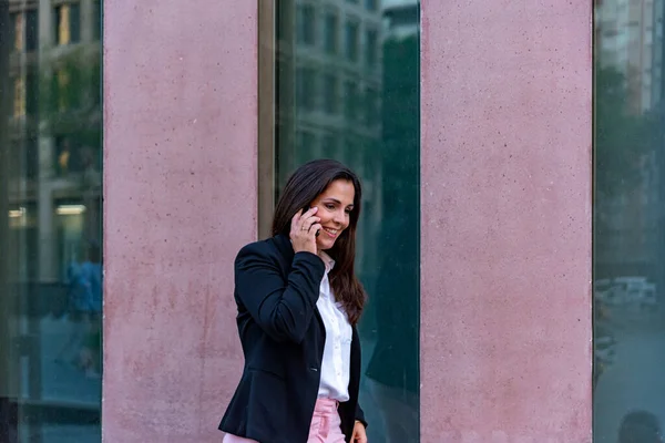 Кавказская предпринимательница разговаривает по мобильному телефону в городе — стоковое фото