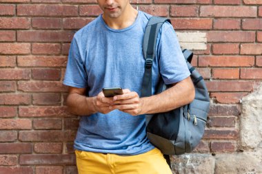 Dışarıda cep telefonu olan genç bir latin.