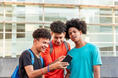 Sokakta cep telefonu kullanan çok ırklı arkadaşlar