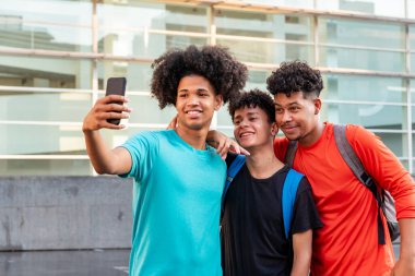 Sokakta selfie çeken çok ırklı arkadaşlar.