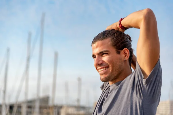 Ung latinsk mann som strekker seg etter trening utendørs – stockfoto