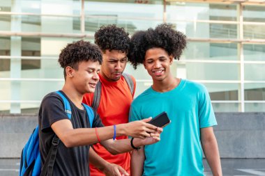 Sokakta cep telefonu kullanan çok ırklı arkadaşlar