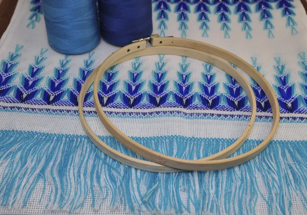 Wooden hoop for embroidery on a table with a thread