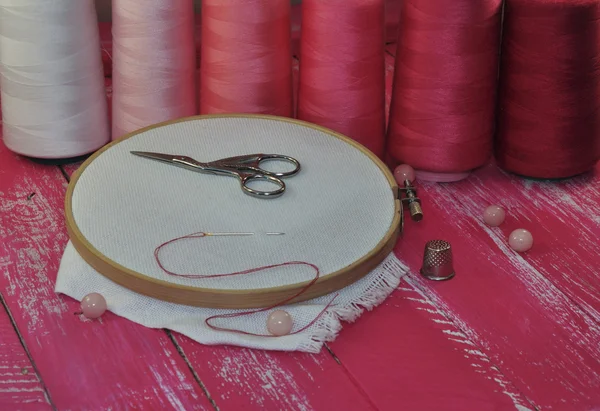 Narzędzia do haftowania nici i czerwonych odcieni na drewnianym stole — Zdjęcie stockowe