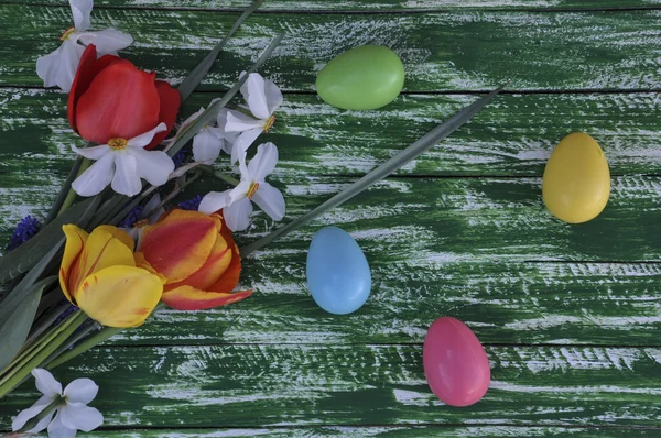 Achtergrond Pasen Lentebloemen en kleurrijke eieren — Stockfoto