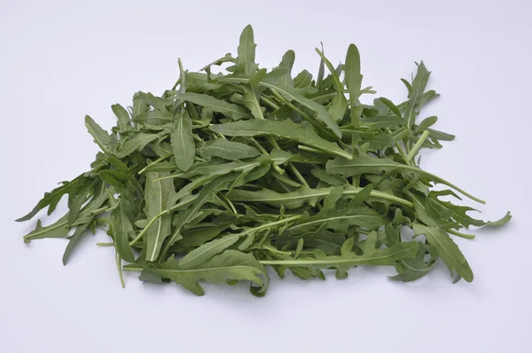 Ruccola på en vit platta, hälsosam sallad — Stockfoto