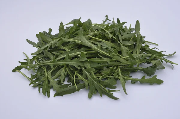 Gröna ruccola på vit bakgrund — Stockfoto