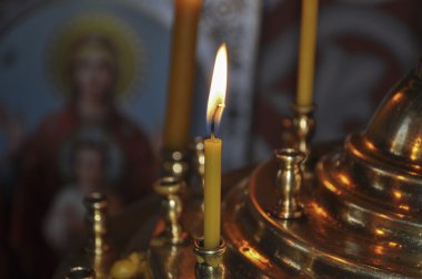 Altın kaplama avizede yanan parlak bir mum.