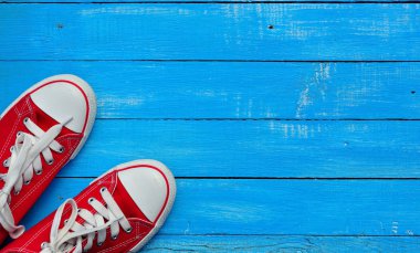 Mavi bir arka plan üzerinde kırmızı spor ayakkabılar