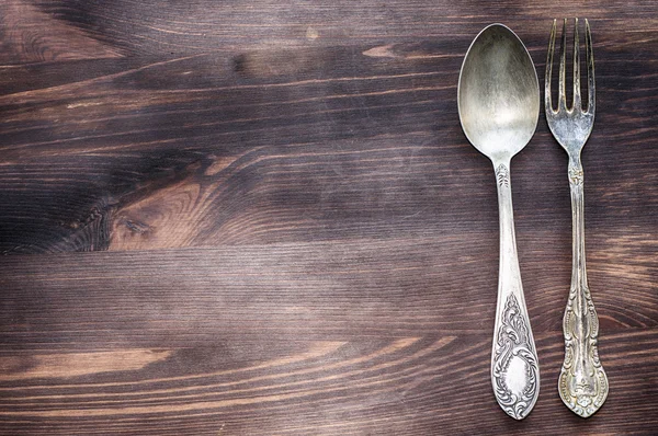 Fondo de madera con tenedor de hierro vintage y cuchara — Foto de Stock