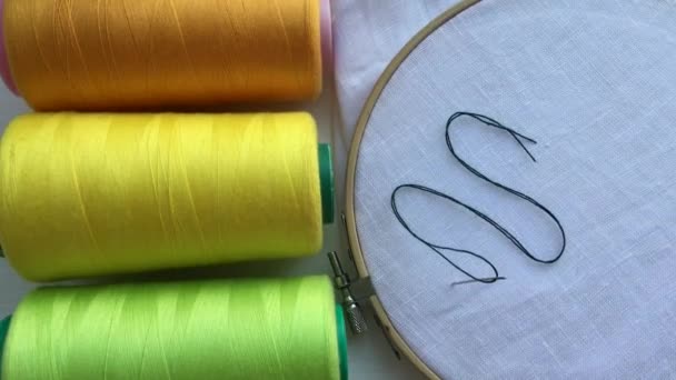 Spools of thread green and wooden hoop with the fabric for embroidery — Stock Video