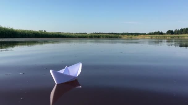 Kleine papieren boot drijft weg op de rivier — Stockvideo