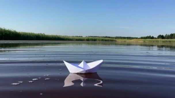 Pequeño barco de papel blanco flota lejos — Vídeos de Stock