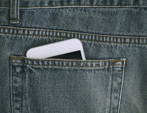 Fragmento de smartphone pode ser visto a partir do bolso de jeans velhos — Fotografia de Stock