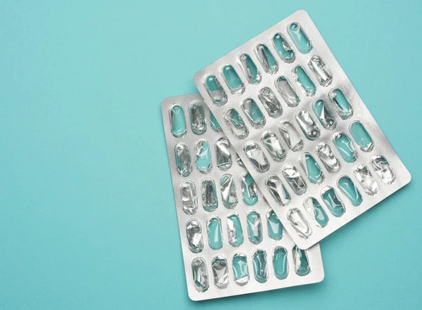 blank blister pack of capsule pills on a blue background, top view