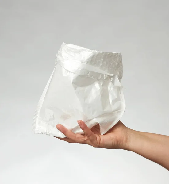 Женская Рука Белым Пластиковым Пакетом Сером Фоне Закрыть — стоковое фото