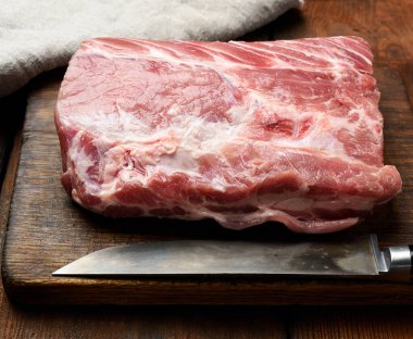Tahta kesme tahtasında çiğ domuz filetosu, üst manzara.