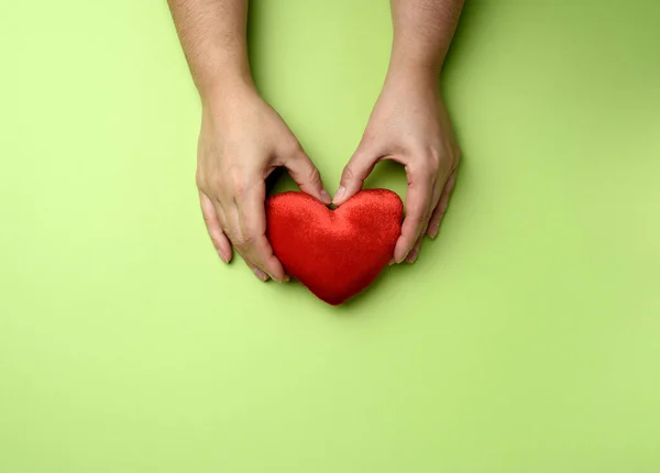 Manos Femeninas Sostiene Corazón Textil Rojo Fondo Verde Concepto Amor —  Fotos de Stock