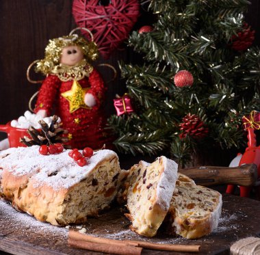 Geleneksel bir Avrupa pastası olan, fındık ve şekerli meyveli Stollen, şekerle kaplanır ve kahverengi bir tahta üzerinde parçalara ayrılır.