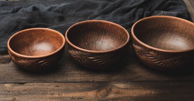 Tahta bir masada boş kahverengi seramik tabaklar, üst manzara.