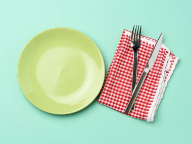 boş yeşil seramik plaka ve metal çatal ve bıçak, yeşil arka plan, üst görüş