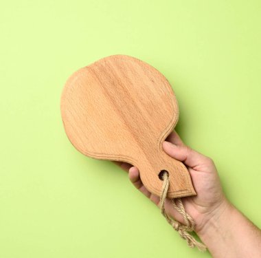 Elinde boş ahşap tahta olan, yeşil arka planı olan bir kadın.