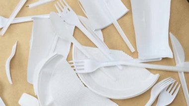 Kahverengi arka planda beyaz plastik geri dönüşümsüz bulaşık makinesi, çevre kirliliği konsepti, üst görünüm