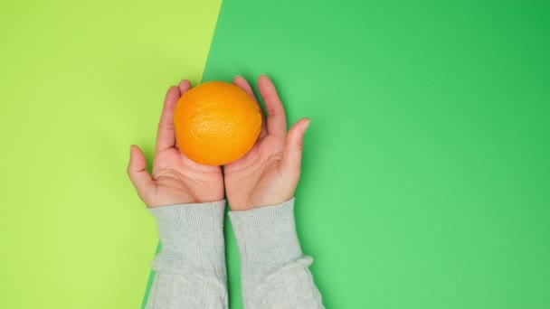 Δύο Θηλυκά Χέρια Τράνταγμα Ένα Ολόκληρο Ώριμο Πορτοκάλι Ένα Πράσινο — Αρχείο Βίντεο