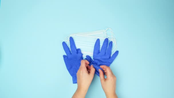 Dwie Kobiety Zakładają Niebieskie Rękawiczki Lateksowe Biorą Medyczną Jednorazową Maskę — Wideo stockowe