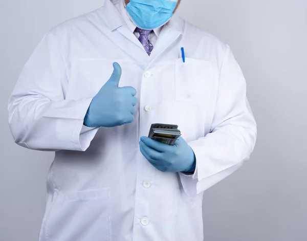 Lekarz Białym Płaszczu Niebieskich Jałowych Rękawiczkach Trzyma Paczkę Papierowych Pieniędzy — Zdjęcie stockowe