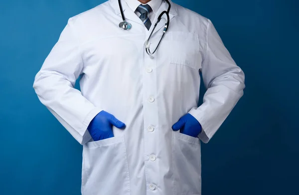 Lekarz Białym Płaszczu Stoi Niebieskim Tle Mężczyzna Krawacie Stetoskop Wisi — Zdjęcie stockowe