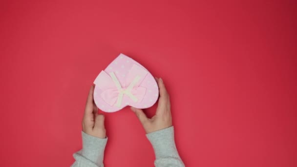Zwei Weibliche Hände Mit Einem Rosa Herzförmigen Geschenkkarton Ansicht Von — Stockvideo