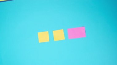 Pembe kağıda boş çıkartmalar yapıştıran kadın eli mavi arka plan, iş konsepti, çoklu görev