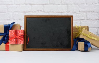 boş ahşap çerçeve ve beyaz tuğla zemin üzerinde çeşitli hediye kutuları yığını, şenlikli fon