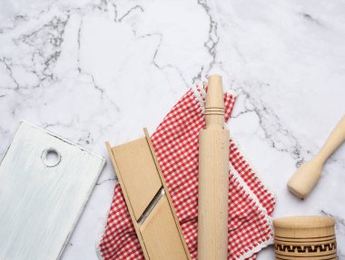 Beyaz mermer masa üzerinde ahşap mutfak aletleri, üst manzara.